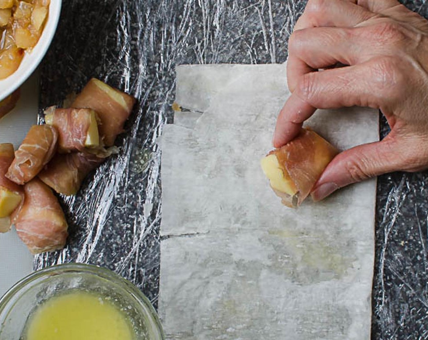 step 8 Fold the dry portion of the dough over on itself and pat to seal. Place a brie and prosciutto bundle in the lower right corner of the phyllo, leaving about 1" edge on either side".