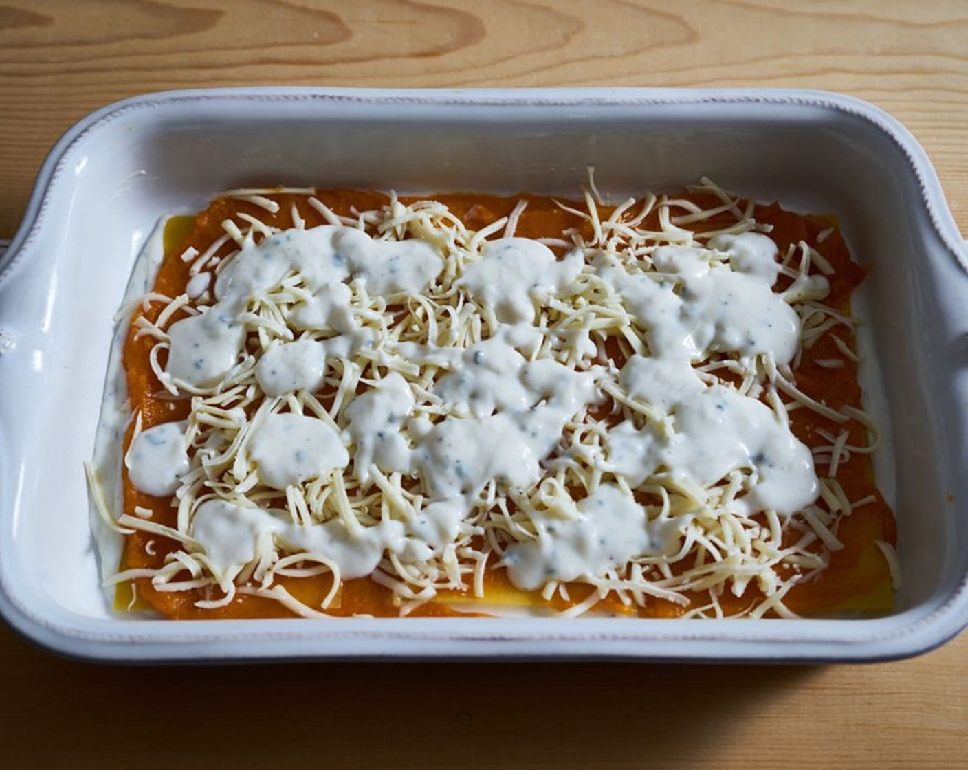 step 6 Add 3/4 cup of the milk mixture to the bottom of the baking dish. Place 3 of the No-Boil Lasagna Noodles (12) on top of the sauce. Spread 1/3 of the butternut squash on top of the noodles. Top with 1/2 cup of the mozz/fontina cheese mixture. Drizzle with 1/2 cup of the bechamel sauce.