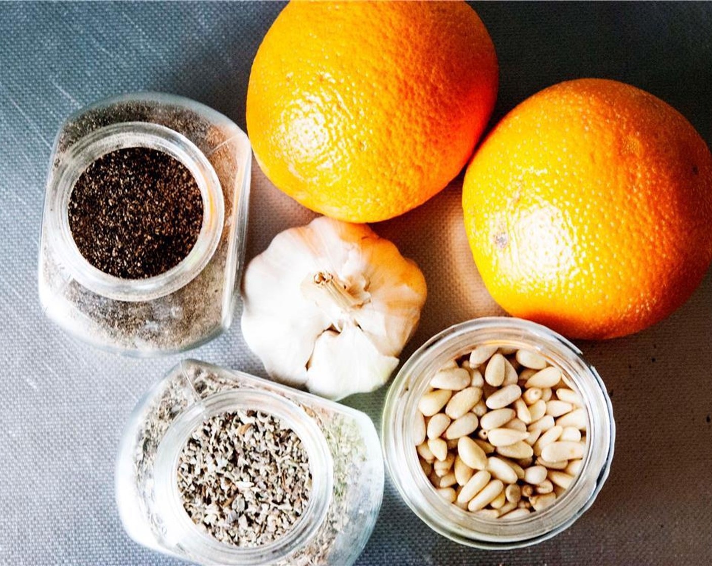 step 2 Grab the ingredients for the rub: Oranges (2), Garlic (1 clove), Pine Nuts (2 Tbsp), Seasoned Salt (1 Tbsp), and Fresh Oregano (1 tsp).
