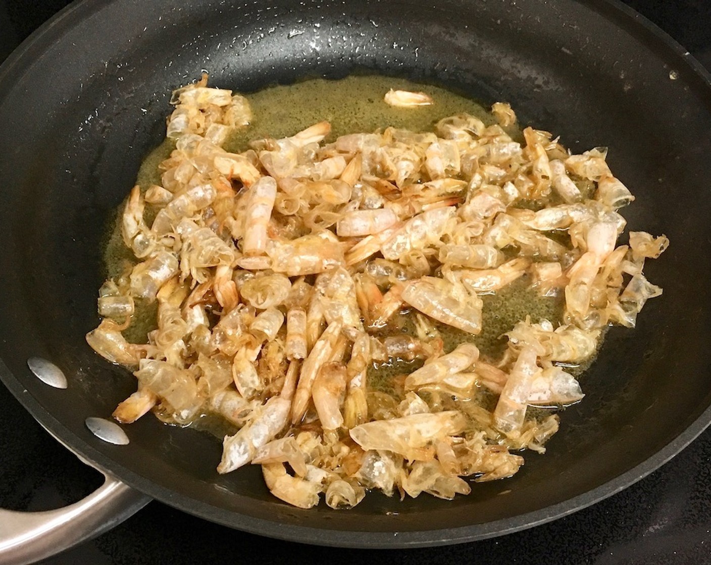 step 2 In a large skillet, heat Unsalted Butter (1/4 cup) and Olive Oil (1/4 cup) over medium-high heat. Add the shrimp shells and sauté for 5 minutes until they are golden and fragrant.