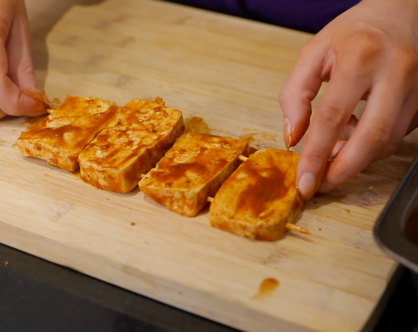 step 5 Meanwhile, make 2 “racks” of vegan ribs. Use two skewers per rack to attach the tofu, leaving space in between.