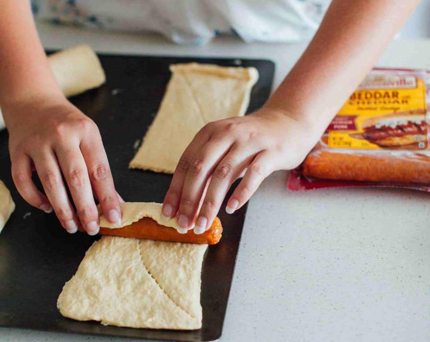 step 3 Roll each Smoked Sausage (1 pckg) up with the crescents, starting from the shorter flat edge so the crescents wrap around a few times.