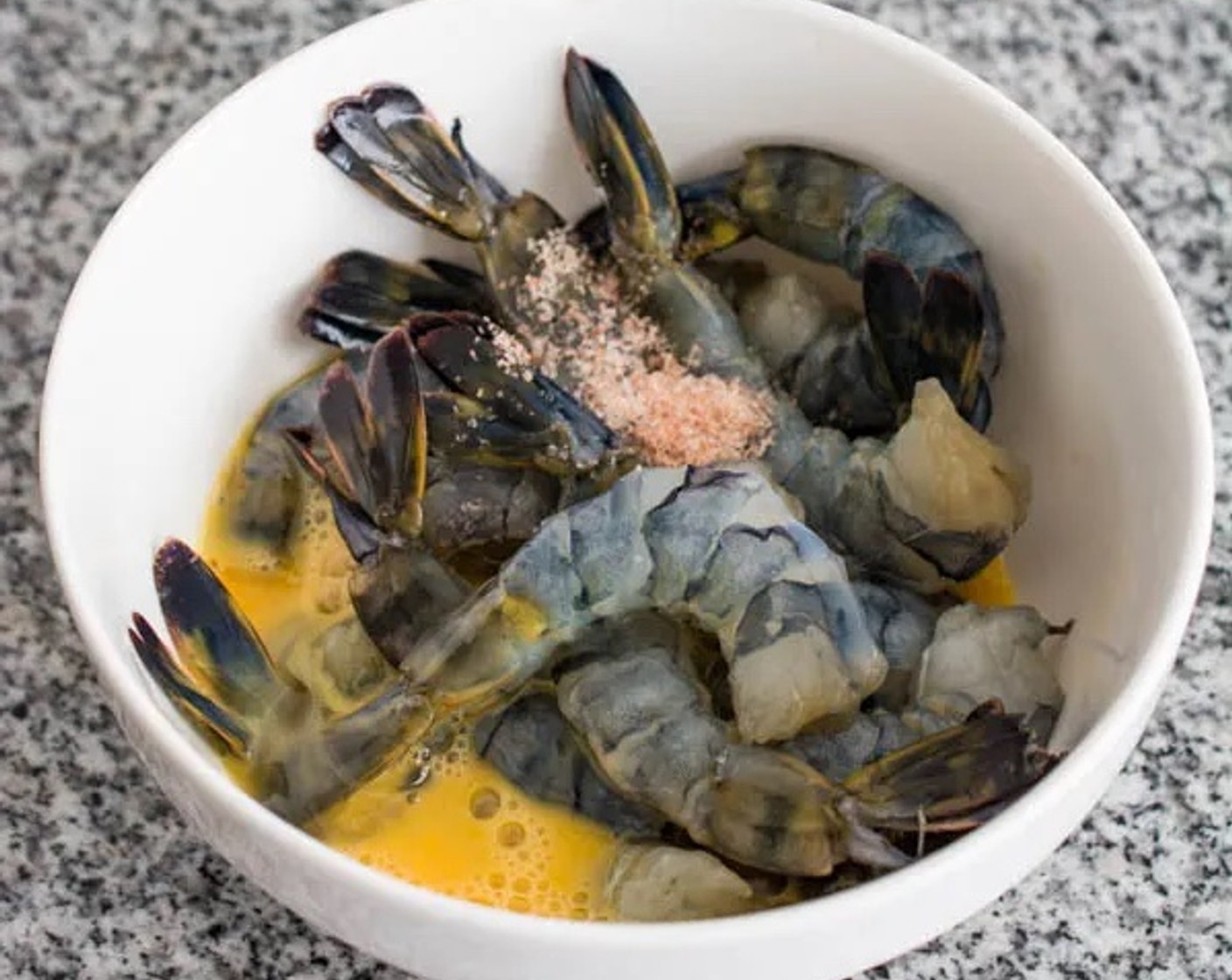 step 4 To prepare the Large Shrimp (1 lb), place them into a bowl together with the Salt (1 tsp) and Eggland's Best Classic Egg (1). Coat the shrimp in the mixture.