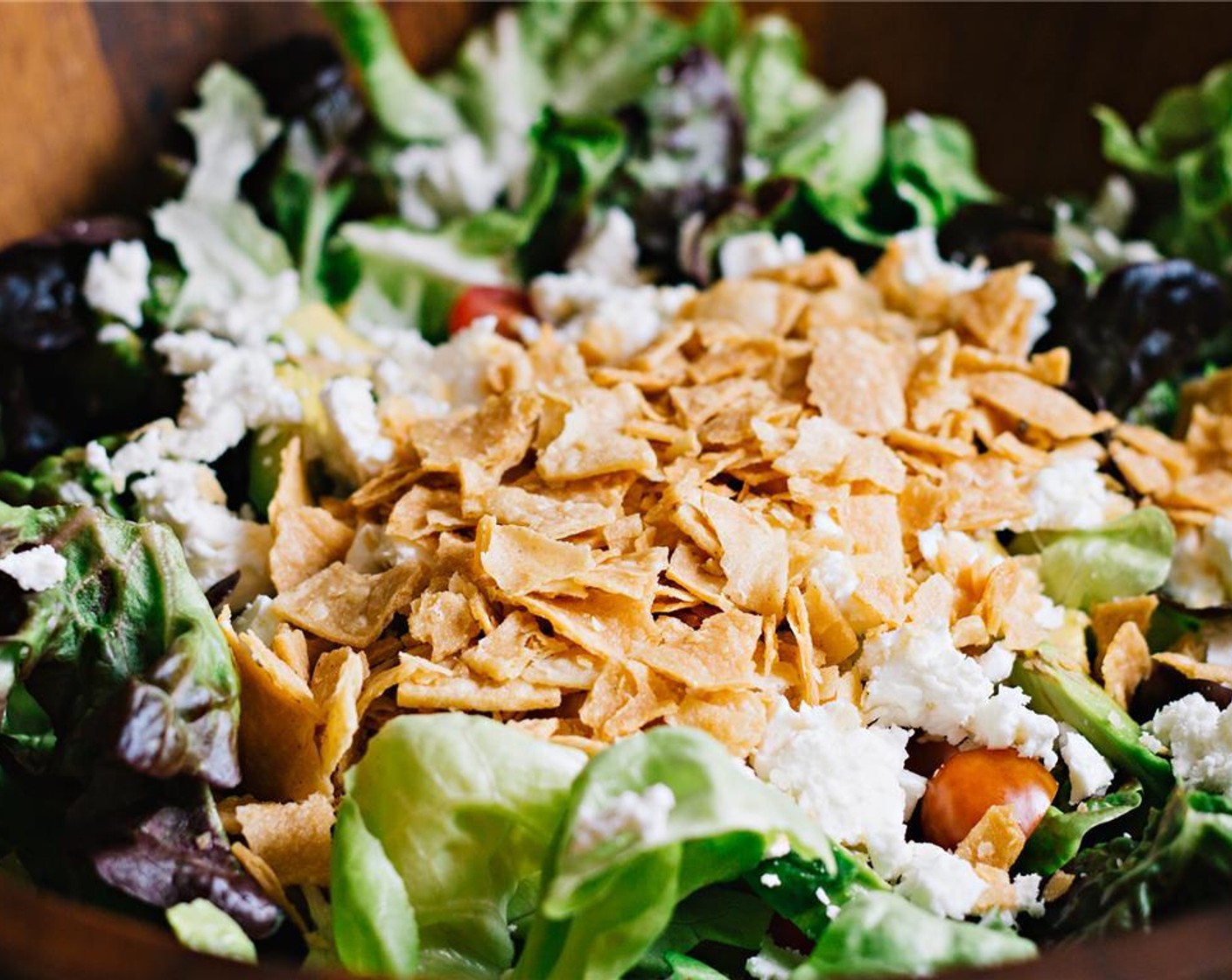 step 8 Die Zutaten in einer Schüssel schichten, beginnend mit dem Salat, gefolgt von den Avocadowürfeln, Tortillas und dem Fetakäse (1/3 Ta.). Dann die übrige Sauce darüber träufeln. Den Salat kurz vor dem Servieren vermengen.