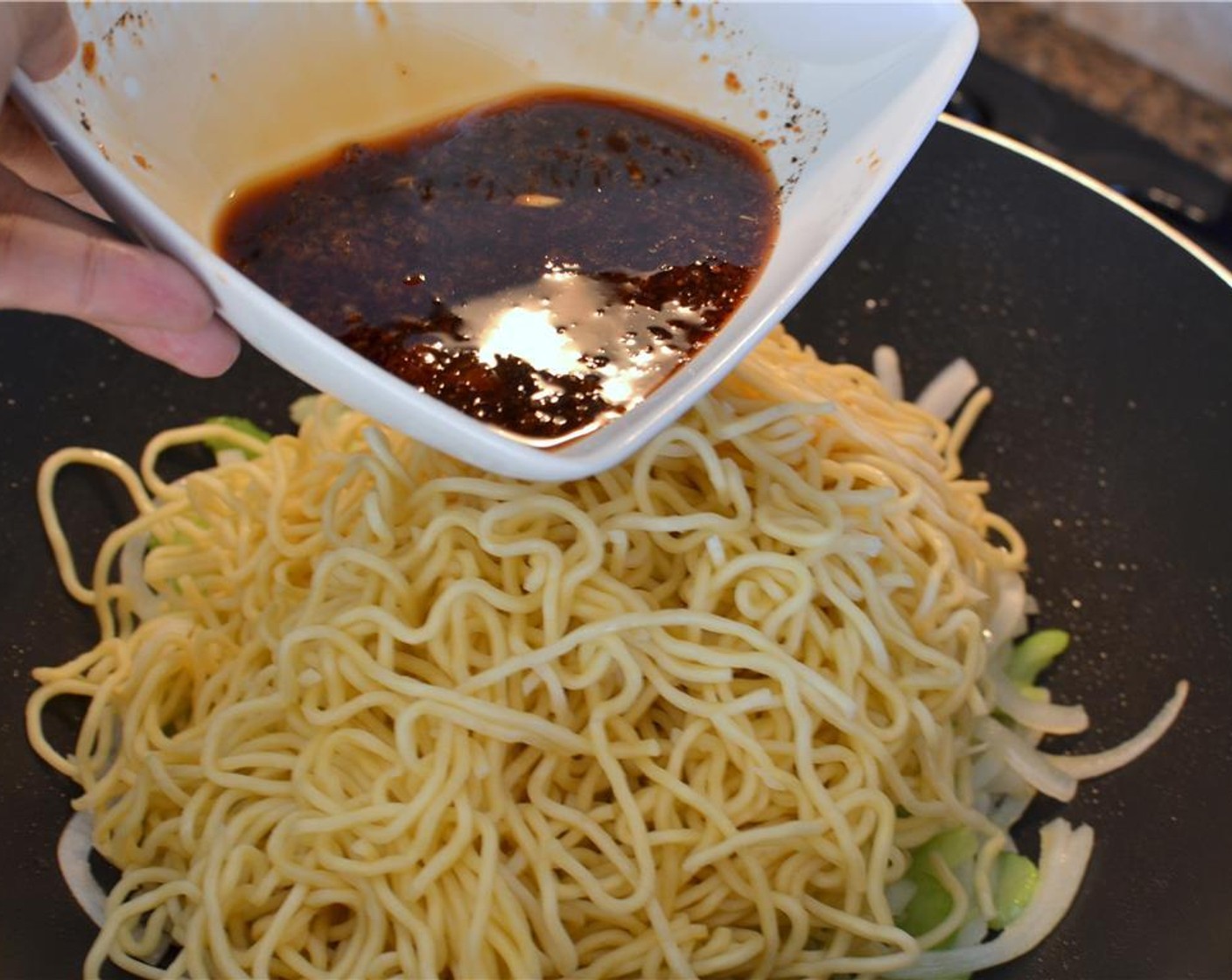 step 8 Immediately add the yakisoba noodles and sauce mixture, tossing and stirring until everything is well coated in the sauce for 2 to 3 minutes.