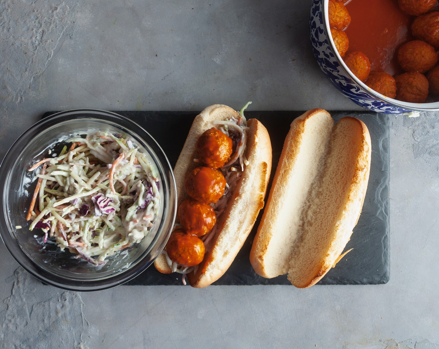 step 5 To assemble, add ¼ cup of slaw to each sub roll. Top with meatballs. Serve remaining slaw on the side.