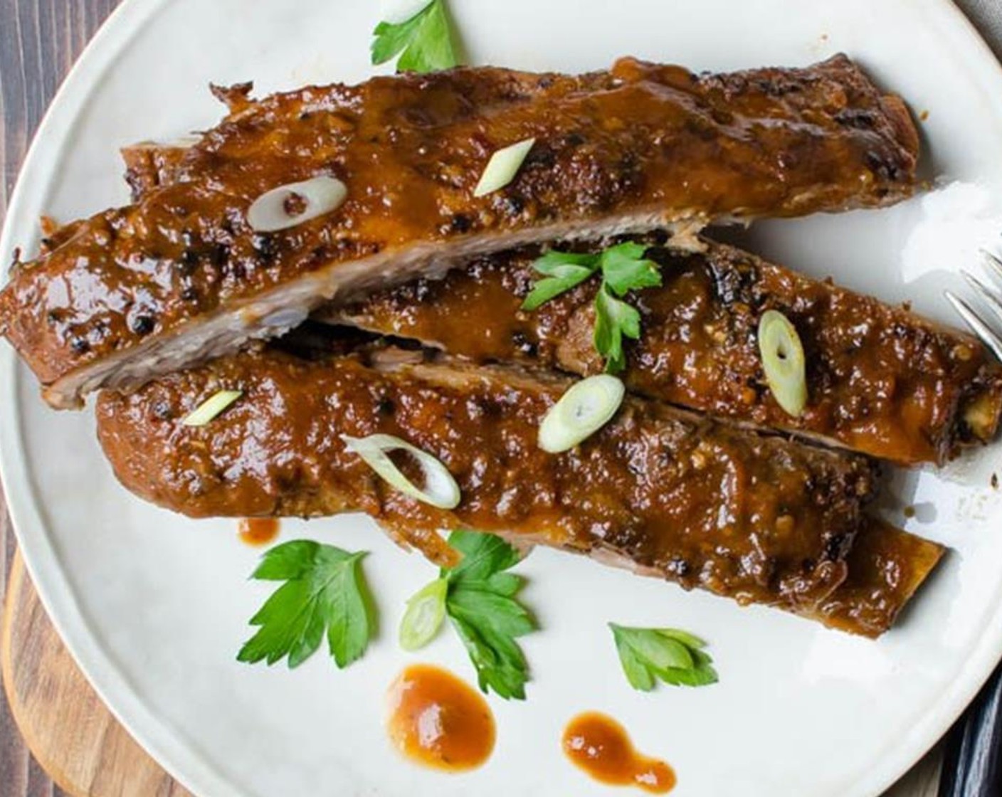 step 13 Transfer the ribs to a cutting board and use a sharp knife to cut between the bones. Sprinkle with optional garnish like Scallions (to taste) and extra Bar-B-Q sauce if desired.