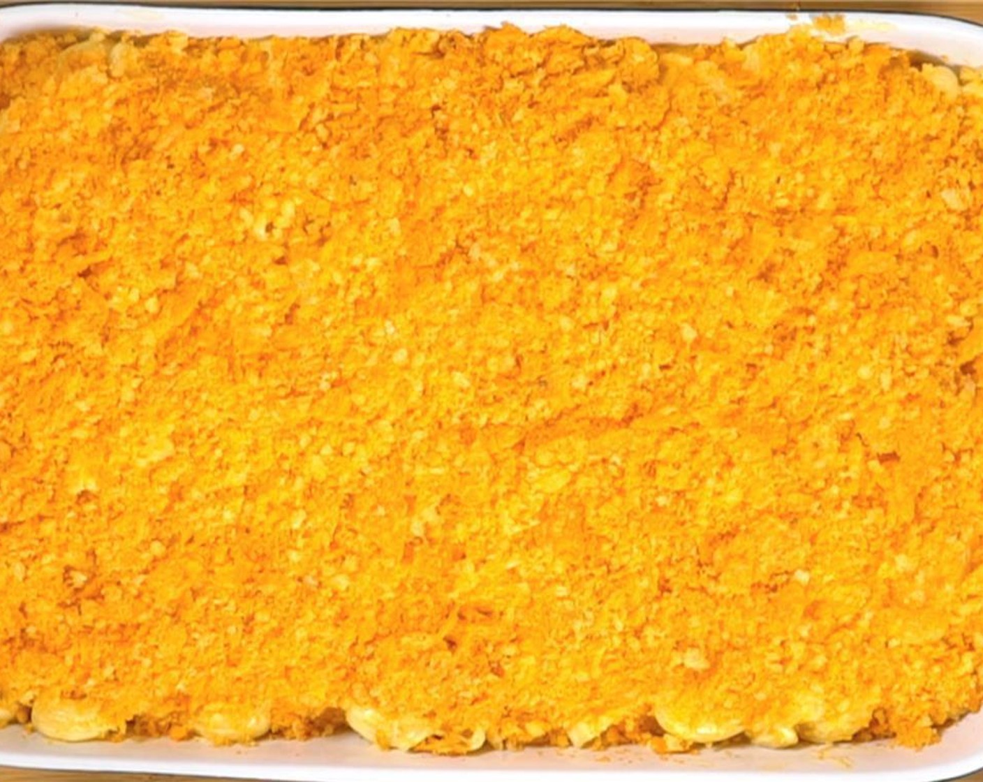 step 6 Add cheesy macaroni to the casserole dish. Crush the bag of Doritos® Nacho Cheese Flavored Tortilla Chips (2 handfuls) and Cheetos Puffs (3 handfuls) by hand or pulse in a food processor a few times, then sprinkle evenly and cover liberally all the way to the edge.