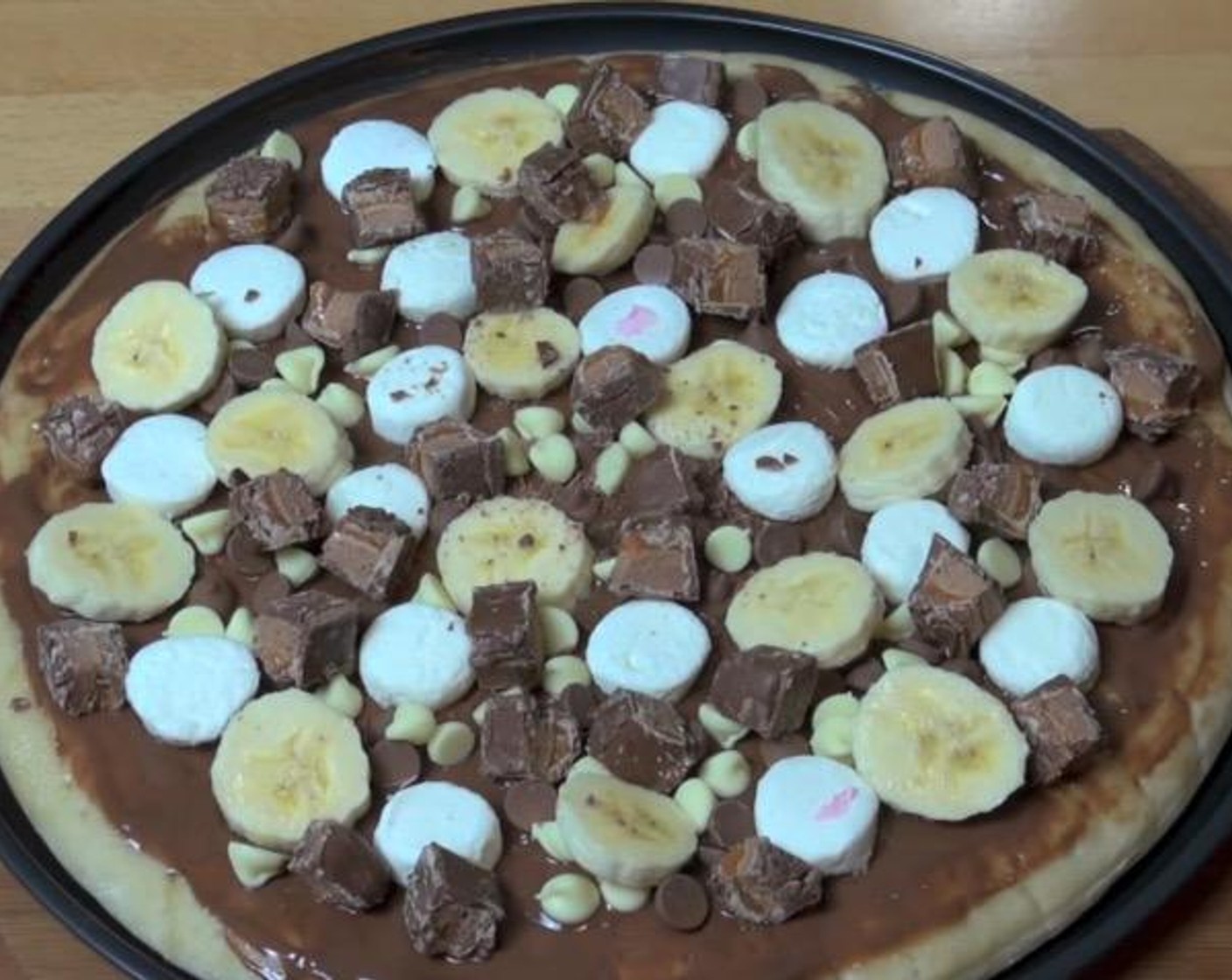step 2 Cover pizza base with Nutella® (1/4 cup). Top with Marshmallows (to taste), Milk Chocolate Chips (1 handful), White Chocolate Chips (1 handful), Banana (1) and Mars® Bars (2).