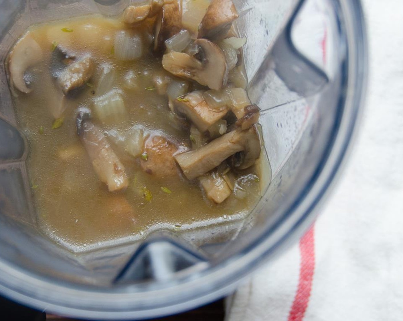 step 6 Working in batches, ladle the mushrooms and broth into a blender.