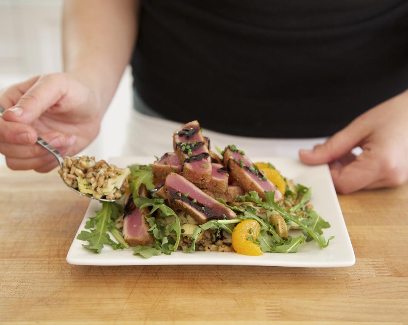 step 12 Top the salad with arugula salad. Present your sliced ahi on top of the warm farro pilaf and drizzle the Balsamic Reduction (2 Tbsp) over the ahi and around the plate for garnish. Garnish with chives. Serve and enjoy!