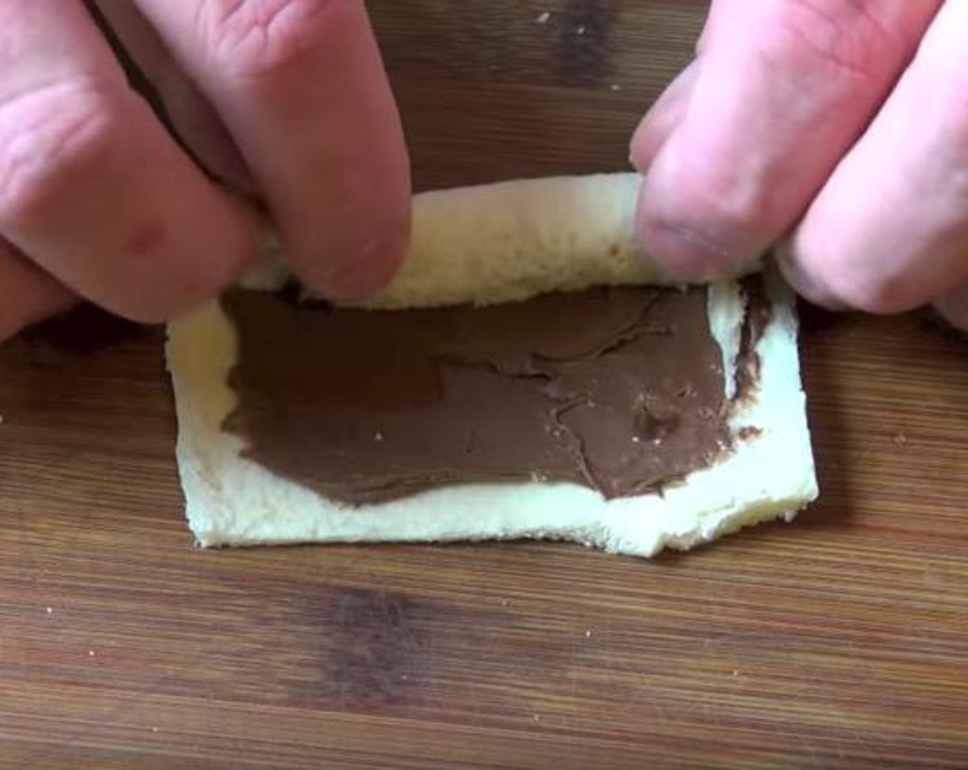 step 2 Take a rolled out piece of bread and spread it with Nutella® (1/2 cup). Gently roll it up to make a nice little roll. Continue on with the rest.