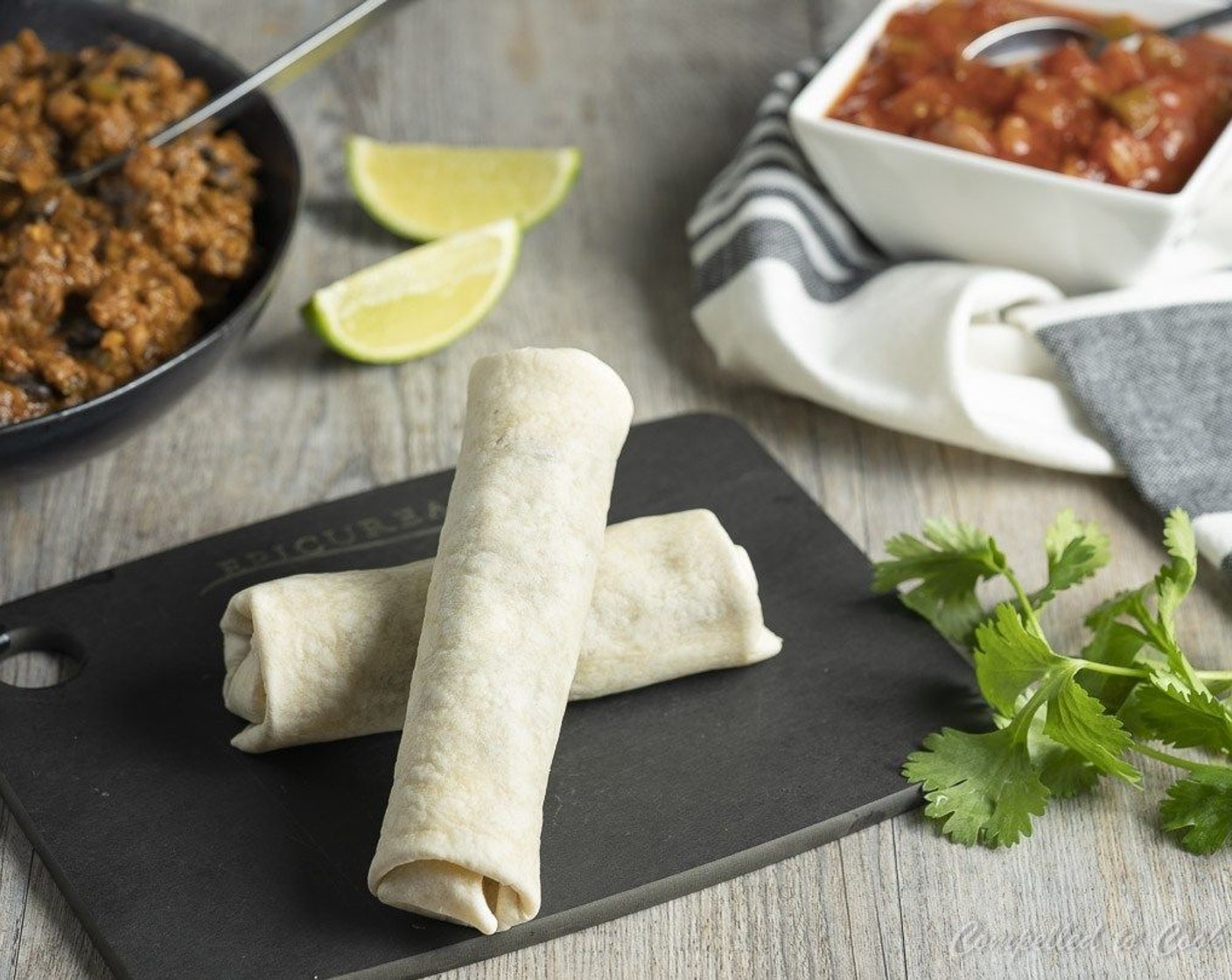step 6 Moisten the top inch of the tortilla with water. Starting from the bottom, roll tortilla shell up a third of the way. Fold in sides 1 1-1/2 inch and continue to roll forward, enclosing all the chili in a tubular shape.