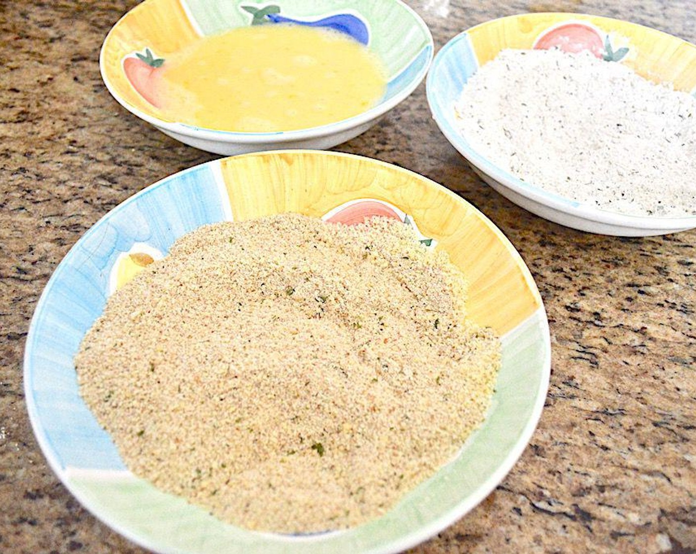 step 4 Take small handfuls of the shrimp to make it go a little faster and dredge them through the flour to coat them with one hand, letting the excess shake off. Then use the other hand to coat them in the egg wash. Go back to the dry hand and coat them in the parmesan and breadcrumbs before you lay them out on the sheet tray.