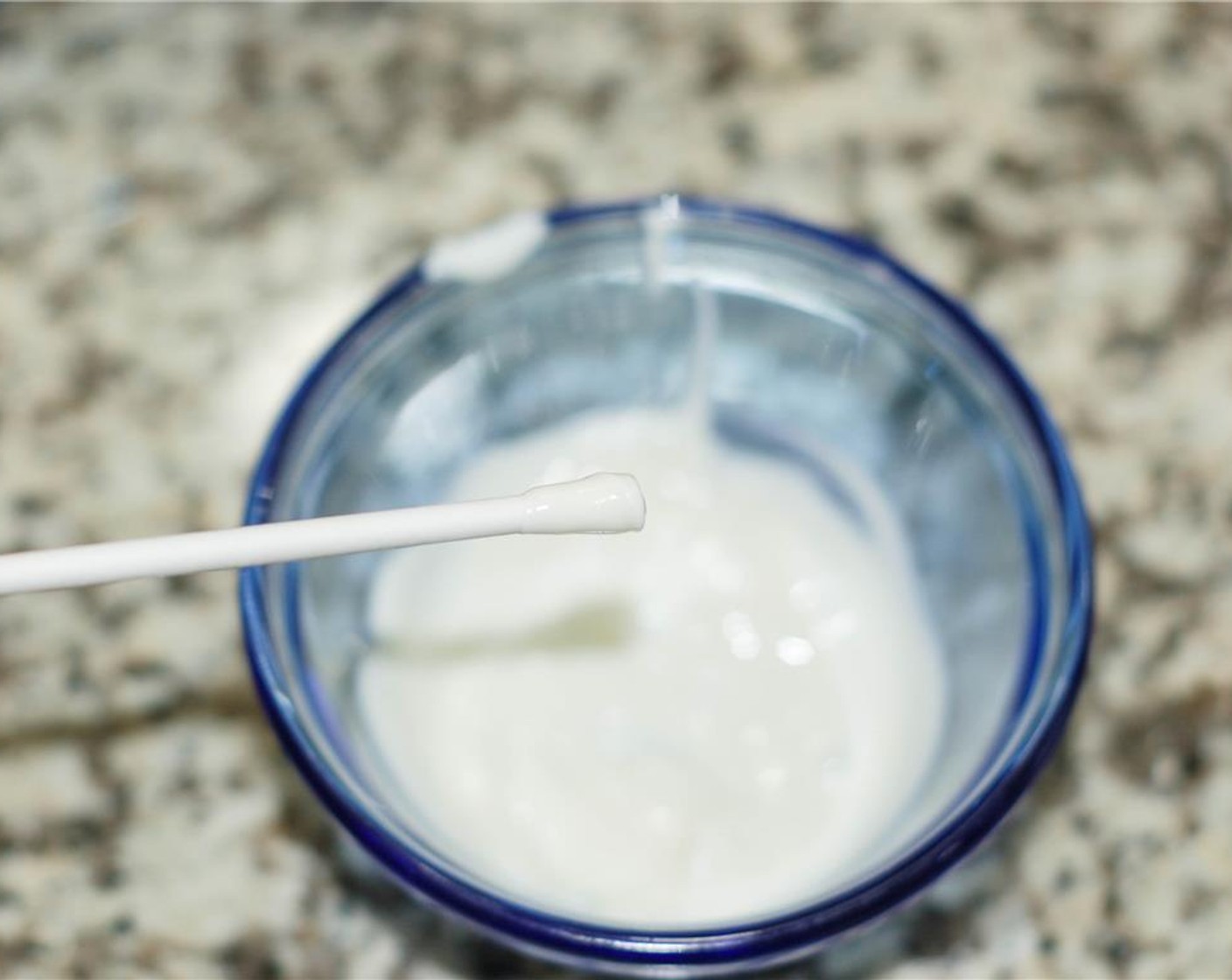 step 5 Place a CANDIQUIK® Vanilla Candy Coating (1 pckg) square in a microwave safe bowl and melt according to instructions on package. Dip the tips of the lollipop sticks into the candy melt. Insert them into the flowers.