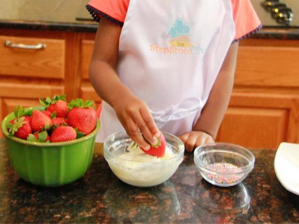 Step 2 of Confetti Dipped Strawberries Recipe: Dip the bottom part of the Fresh Strawberry (12) in the yogurt mix.