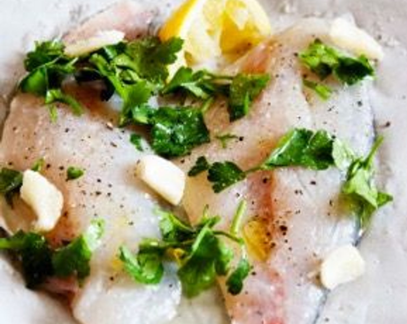 step 2 Onto a baking tray layered with parchment paper, place the Skin-On Orata Fillets (2) skin down. Season with Extra-Virgin Olive Oil (1 Tbsp), Kosher Salt (to taste) and Freshly Ground Black Pepper (to taste), and Fresh Parsley (to taste).