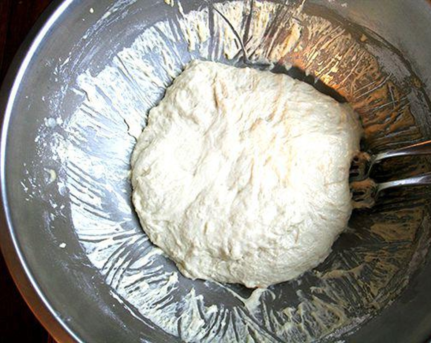 step 6 Using two forks, punch down your dough, scraping it from the sides of the bowl, which it will be clinging to. You want to loosen the dough entirely from the sides of the bowl, and you want to make sure you've punched it down.