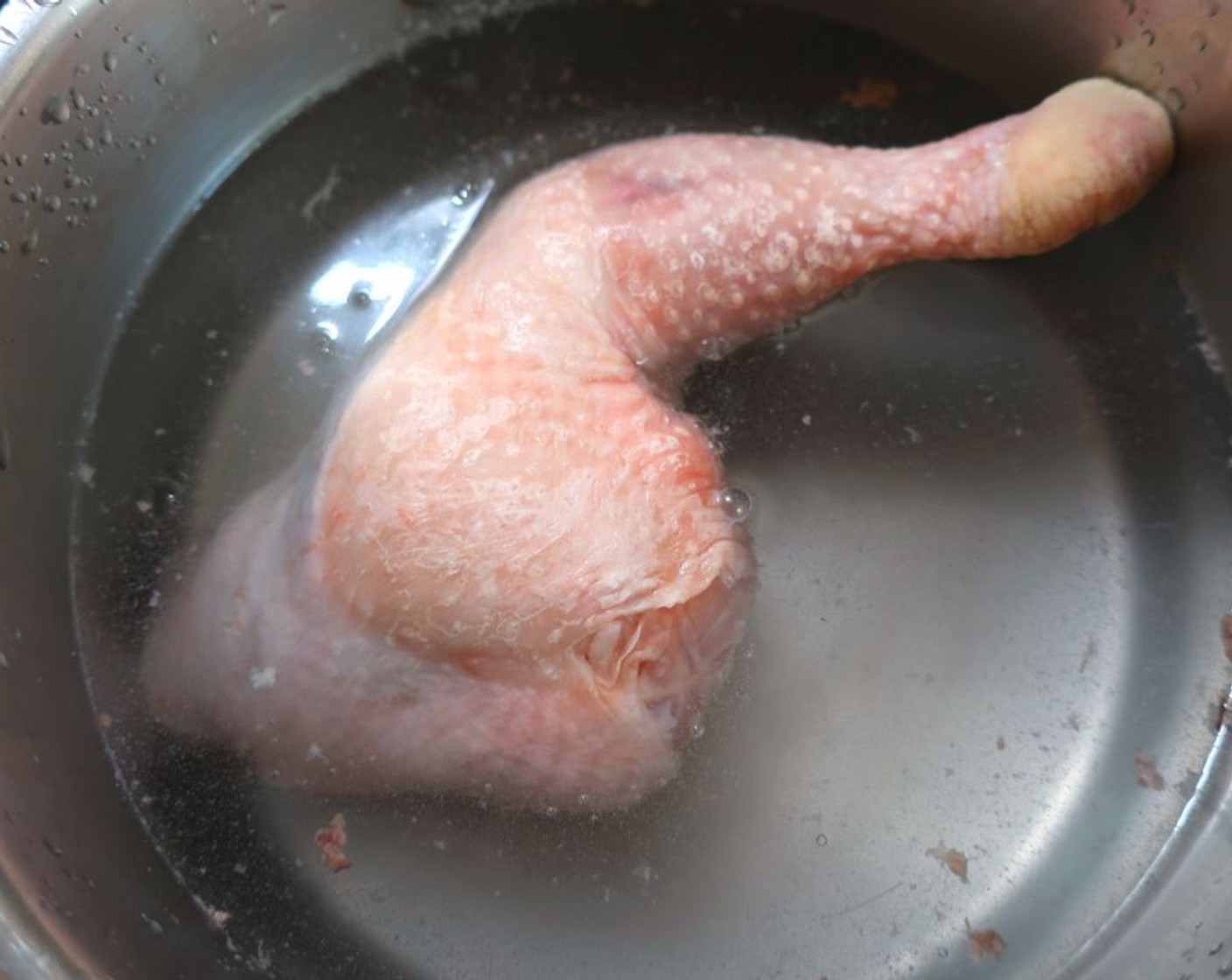 step 1 Blanch Bone-In, Skin-On Chicken Leg (1) in salted water, discard water, cover the leg with Chicken Stock (to taste). Season with Kosher Salt (to taste), Fresh Ginger (to taste), Garlic (to taste), Togarashi Chili (to taste) and Furikake (to taste). Simmer for 45 minutes to 1 hour.