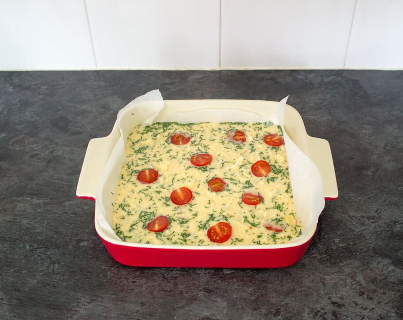 step 6 Next, pour the mixture into your prepared dish. If you need to, spread the bacon pieces out a little with a fork. Now scatter over the remaining Aged Cheddar Cheese (3 1/2 Tbsp) and dot the Cherry Tomatoes (6) on the top facing upwards.