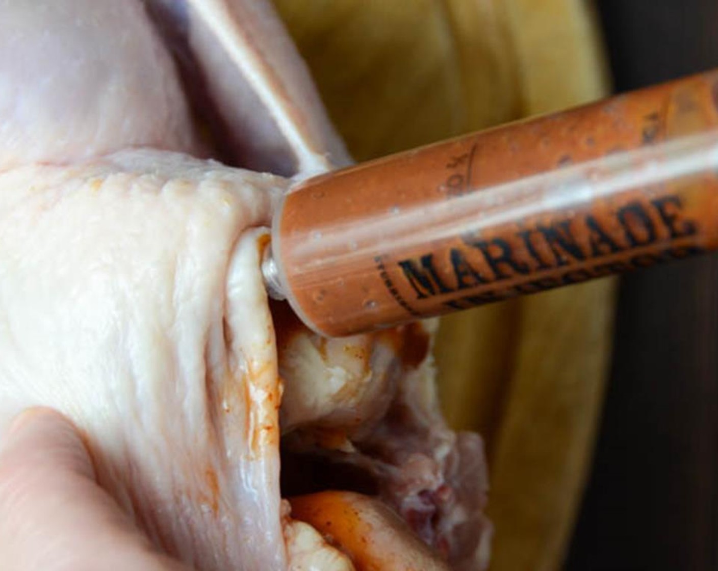 step 5 Start at the neck portion of the Whole Chicken (1), injecting down under the skin and directly into the breast meat of the chicken. Holding the bird upright, inject some marinade into the meatiest part of the thighs.  You'll have to pierce the skin over the thighs but keep the bird upright to mitigate the marinade seepage.