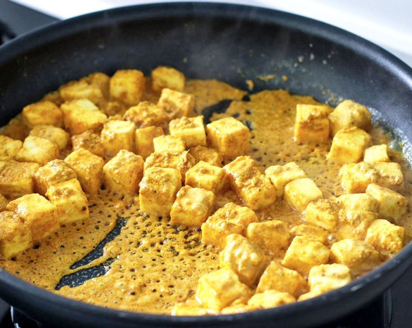 step 3 When ready to cook, heat the Unsalted Butter (1 Tbsp) and Olive Oil (1 Tbsp) in a large nonstick skillet or frying pan over medium-high heat. Once hot, add the marinated paneer and the remaining marinade in the bowl to the pan. Cook for 5-6 minutes, while carefully turning the paneer with a spatula, until the marinade is no longer “wet.” Turn off the heat and set the pan aside.