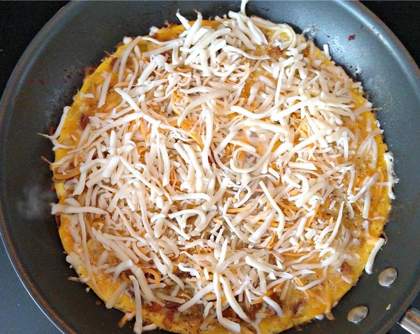 step 8 Once you've reached jiggly perfection, sprinkle Shredded Cheese (1/2 cup)  over the top of the frittata and place frittata with uncooked cheese into your preheated oven set to broil.