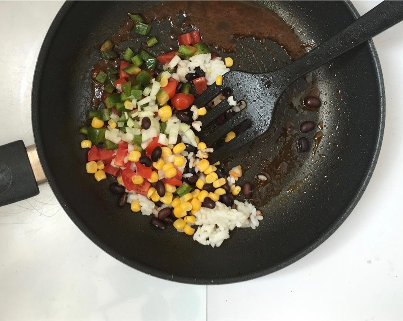 step 5 Stir well and let the tomato paste reduce. Then take the pan off the heat and add the Canned Black Beans (3 Tbsp), Green Bell Peppers (3 Tbsp), Cherry Tomatoes (2), Corn Kernels (2 Tbsp), Onions (2 Tbsp) and cooked White Rice (1 Tbsp).