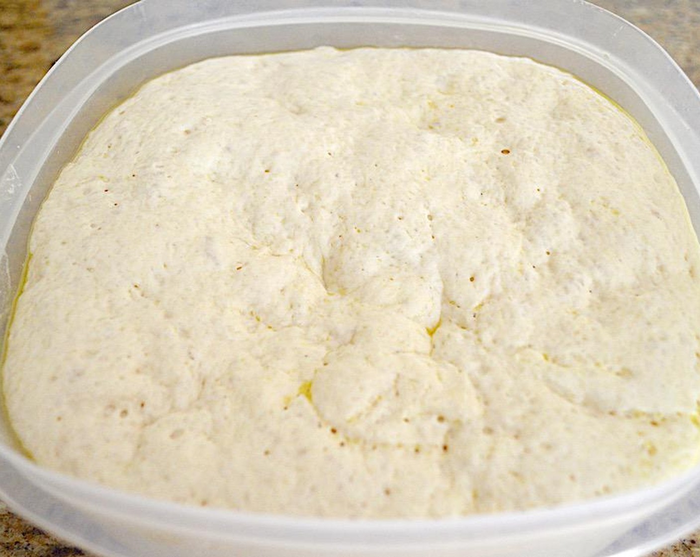 step 5 When the time is up and the dough is huge, dust a clean work surface really well with more Bread Flour (to taste) and Semolina Flour (to taste). Get two sheet trays, line them with silicone mats, and dust them as well.