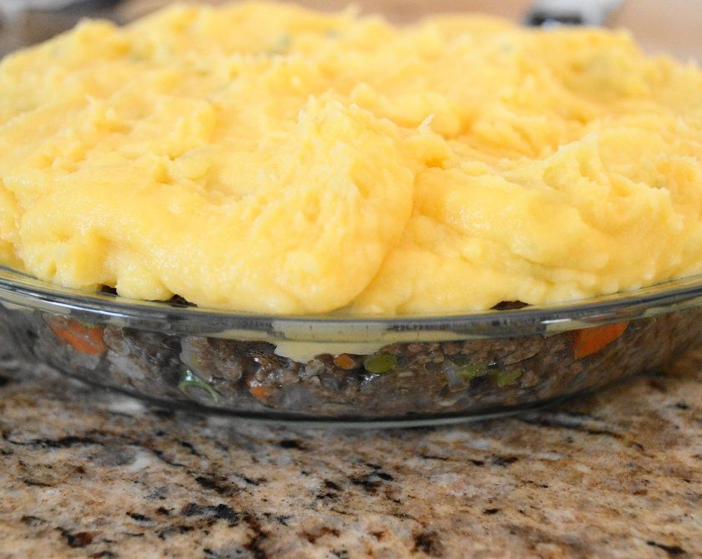 step 9 Stir in the Egg (1) yolk once it has cooled a bit to make them extra rich. Pack the meat mixture tightly and evenly in the pie dish, pressing it down firmly. Scoop the mashed potatoes on top and smooth them out into an even layer. Be sure to seal the meat mixture in with the potatoes.