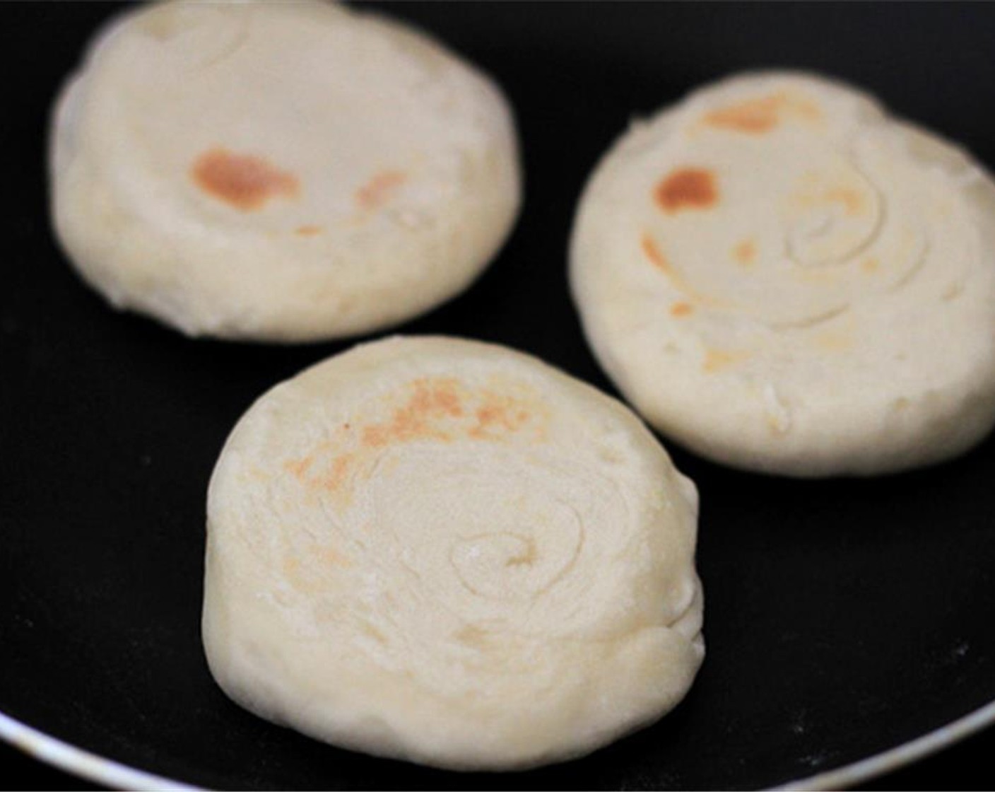 step 10 Heat up a pan. Place the bowl shaped dough in a pan to fry until slightly brown over medium fire. Turn over to fry the second side. Repeat the process to finish all the buns.