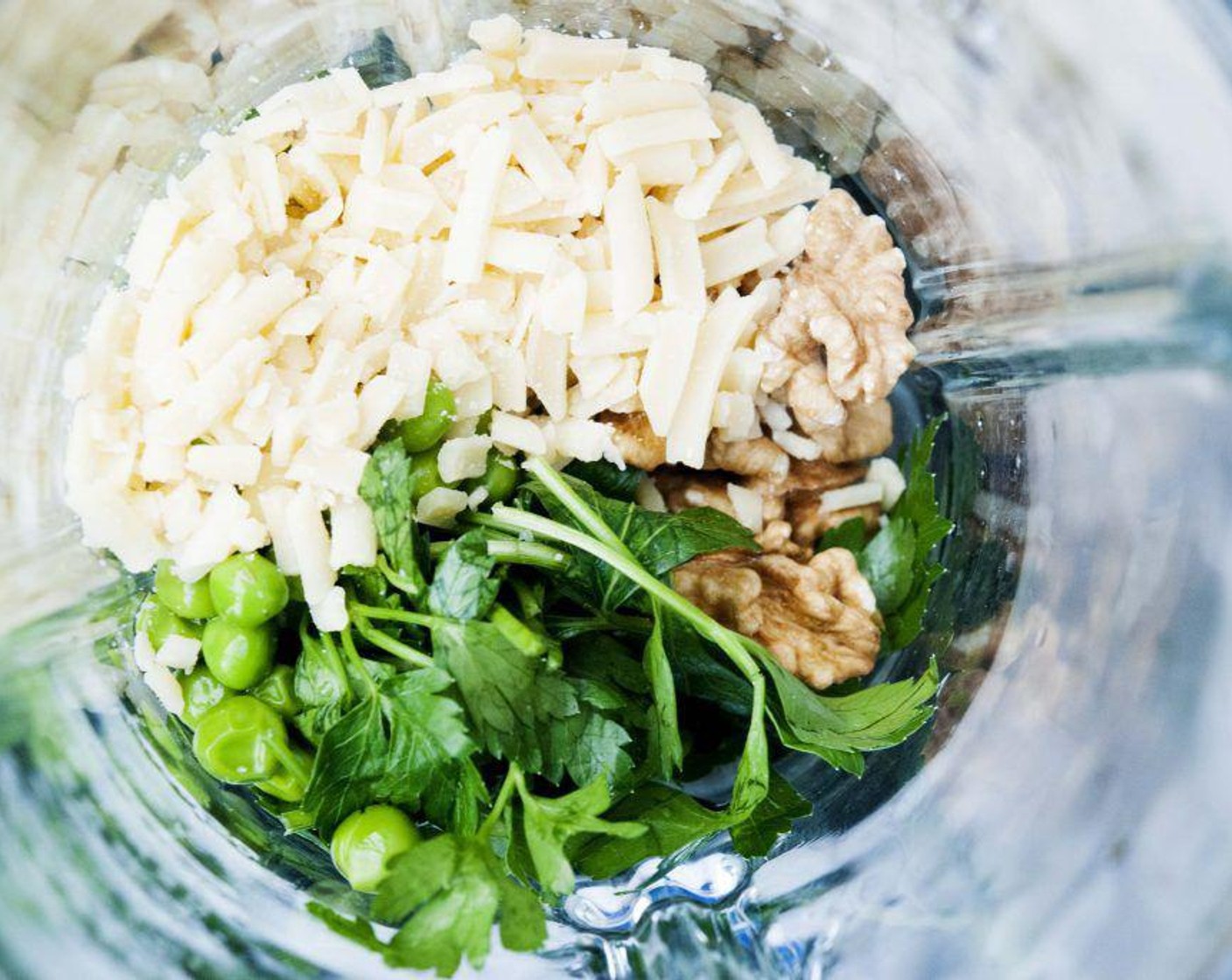 step 1 In a blender or food processor combine Green Peas (1 cup), Fresh Parsley (1/2 cup), Raw Walnuts (1/4 cup), Parmesan Cheese (1/3 cup), Garlic (1 clove), and 2 tablespoons of water. Pulse until paste forms.