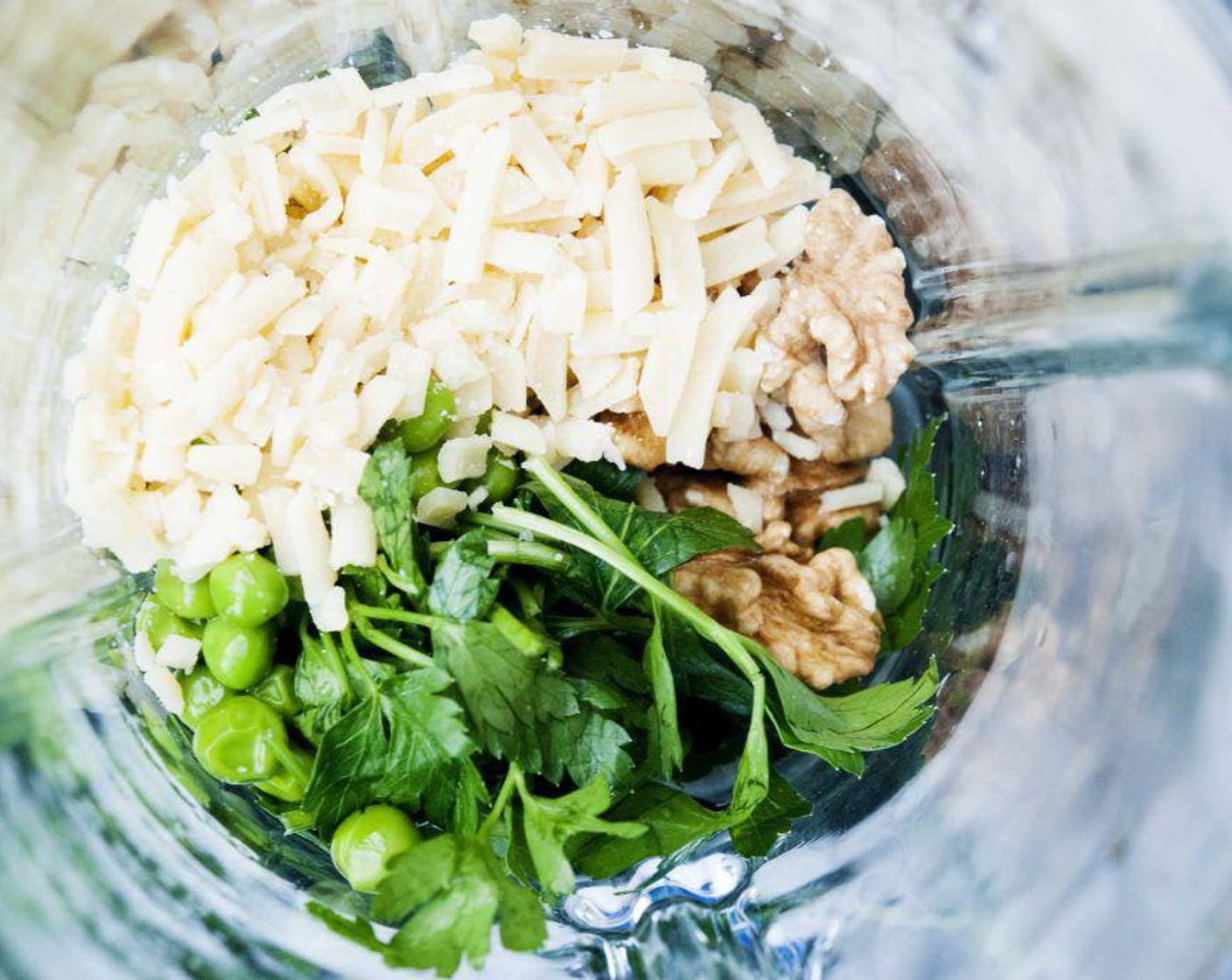 step 1 In a blender or food processor combine Green Peas (1 cup), Fresh Parsley (1/2 cup), Raw Walnuts (4 Tbsp), Parmesan Cheese (1/3 cup), Garlic (1 clove), and 2 tablespoons of water. Pulse until paste forms.