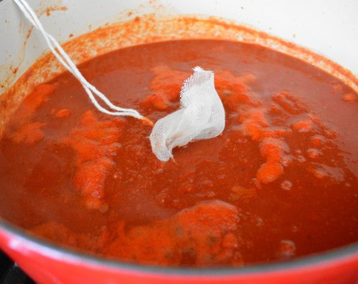 step 5 Pour in the Chicken Stock (1 1/2 cups), Crushed Tomatoes (2 cans), and Parmesan Cheese (4 Tbsp). Add the herb bundle you made and submerge it into the sauce, then allow it to come to a boil. Reduce it to a simmer and let it gently bubble for 2 hours.