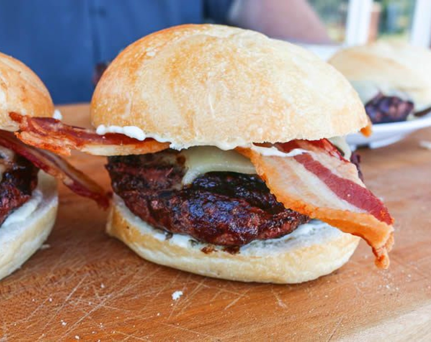 step 14 Place burger patty on the bottom half of each roll and top with 2 slices of Thick-Cut Bacon (12 slices), the top half of the Kaiser roll, and serve.