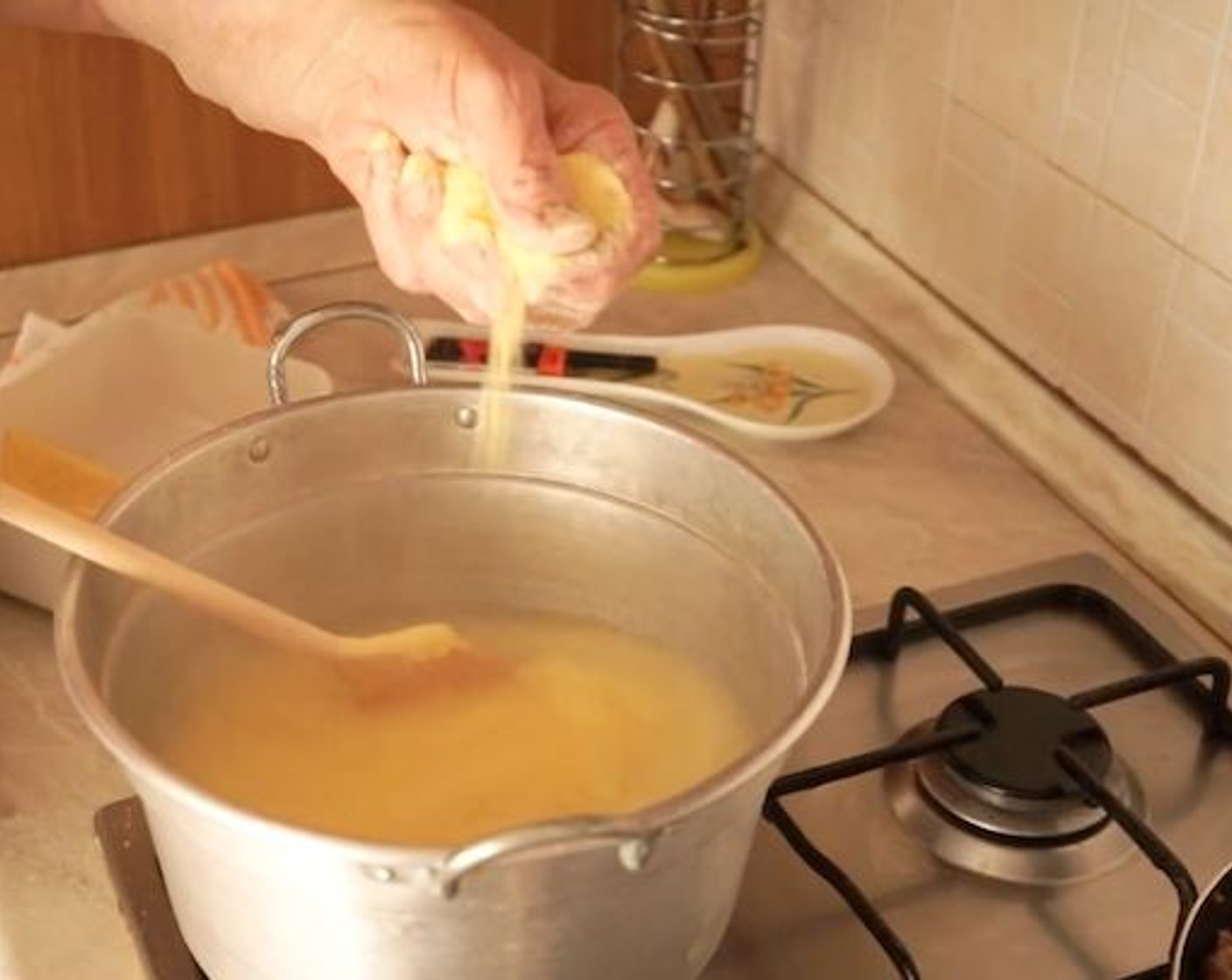 step 7 Put a large pot on the stove, filling it with Water (4 cups). Leave it to heat up – but don’t boil it! Add a pinch of Rock Salt (to taste) to the water once it starts to heat and with the wooden spoon in one hand, get Cornmeal (2 cups) in the other and slowly drop it into the water, while mixing it through with the spoon.