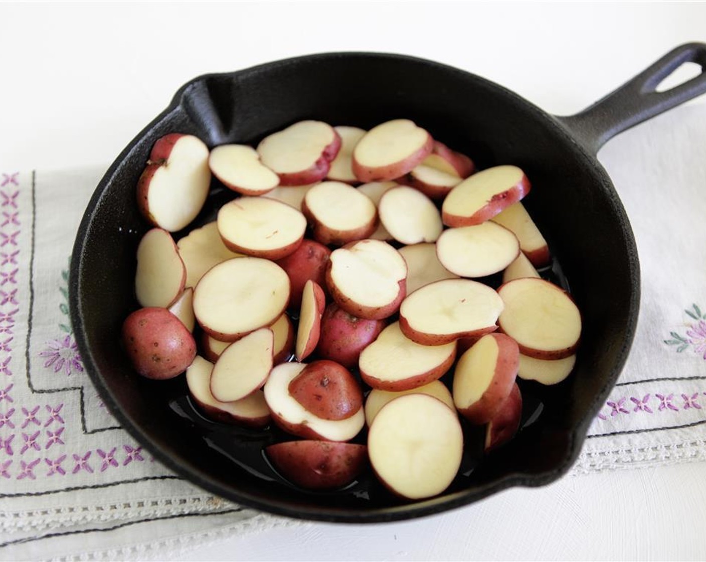 step 2 Place New Potatoes (2 1/4 cups) and Olive Oil (1/2 Tbsp) in a 10-inch cast-iron skillet, season with Kosher Salt (1/2 tsp), and toss to combine.