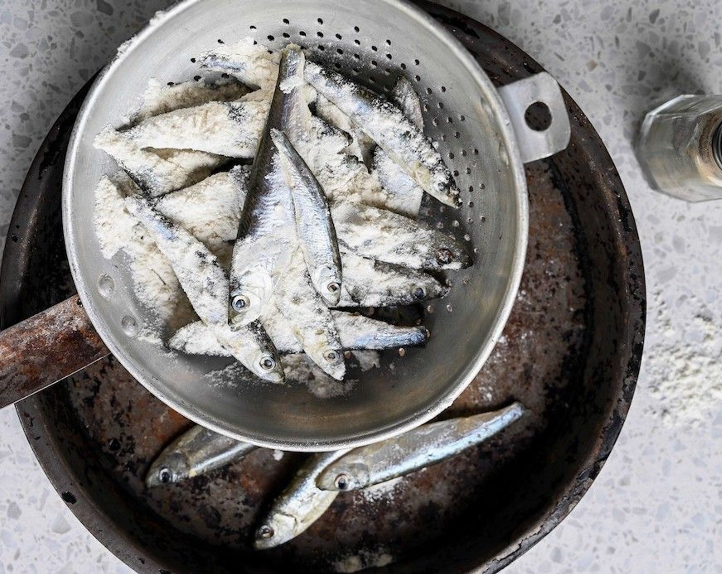 step 6 Rinse off the Frozen Whitebait (2 lb) and pat dry with kitchen towel. Combine the All-Purpose Flour (3/4 cup) and a shake of Ground Black Pepper (to taste) in dish and drop in the whitebait. Shake the dish to evenly coat each fish in flour.