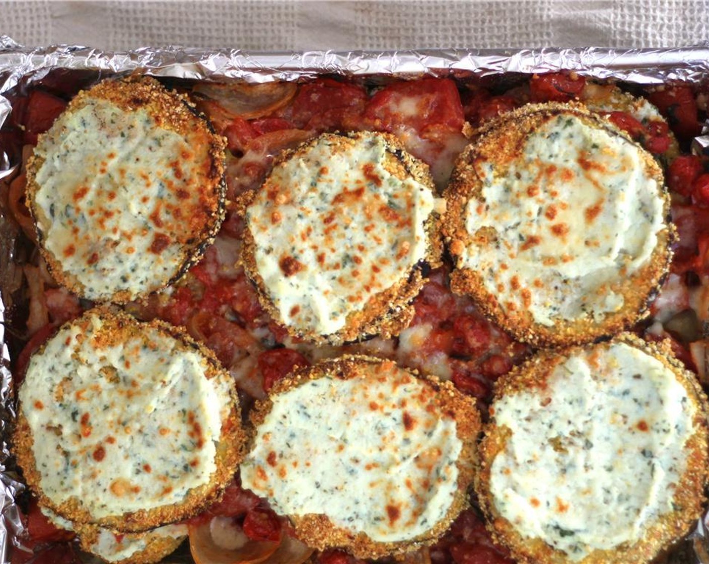 step 10 Repeat the layers of eggsplant, tomatoes, and Parmesan, finishing with just a layer of eggplant and Parmesan on top. Cover and bake for 20 minutes, and then uncover and bake until golden brown on top.