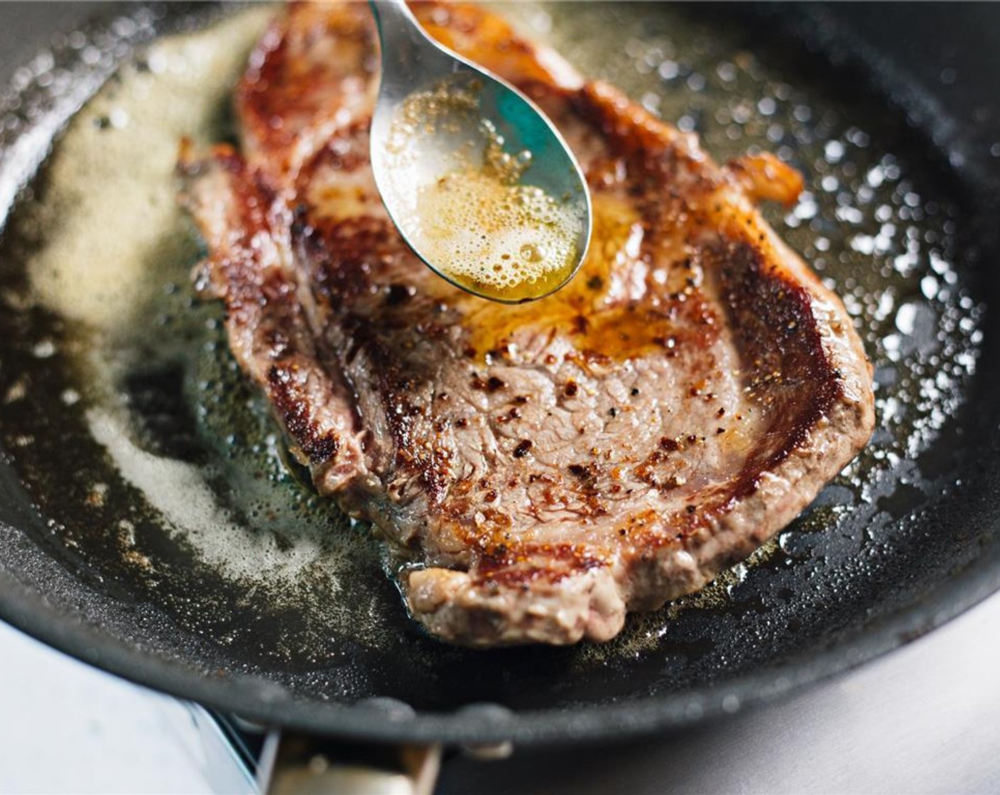 step 8 Baste steak by spooning the hot butter over the steak.