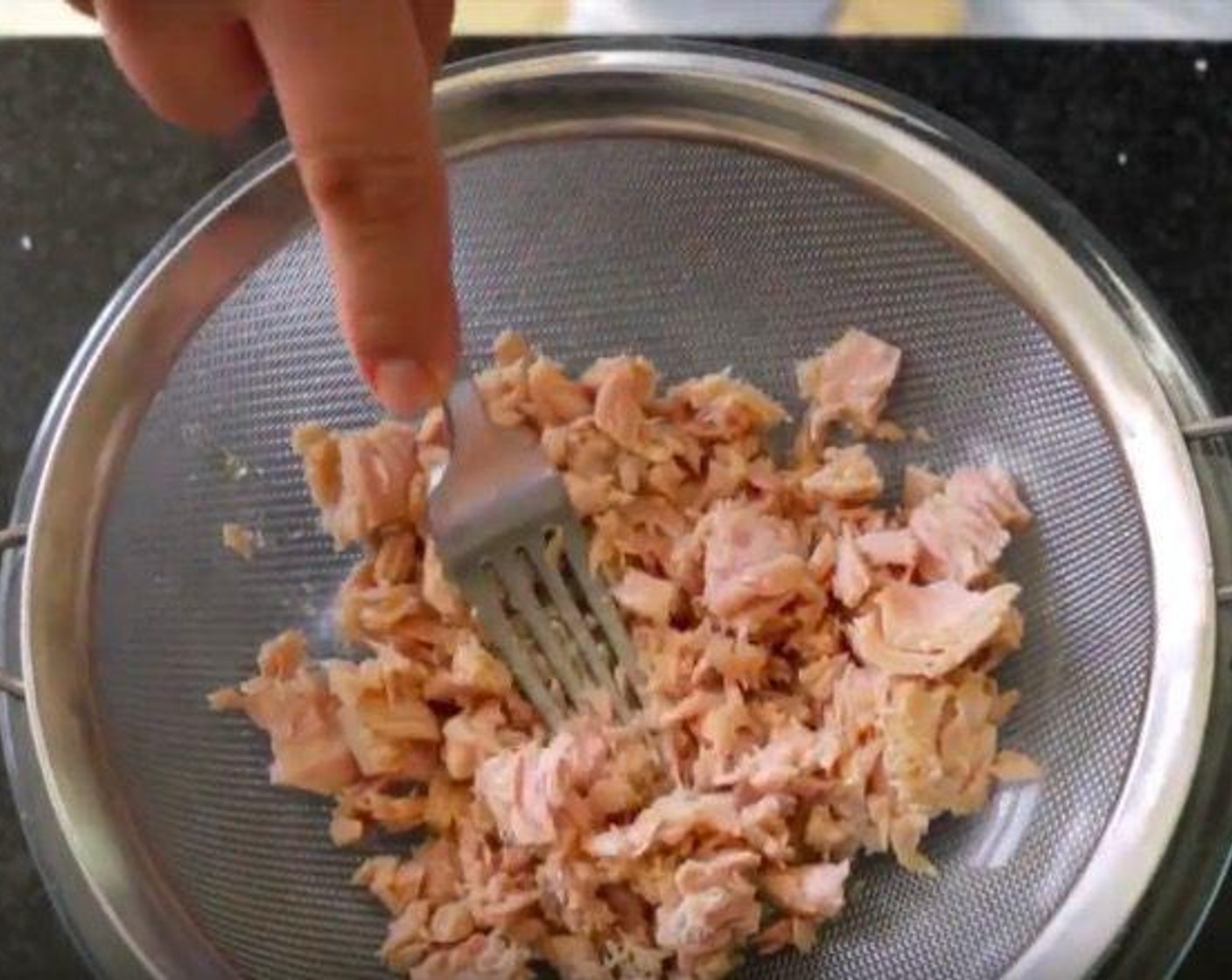 step 4 To make the tuna cakes grab the Canned Tuna (2 cans), drain the liquid, add the tuna to a sieve and using a fork flake the tuna to remove any excess liquid, add the tuna to a large bowl.