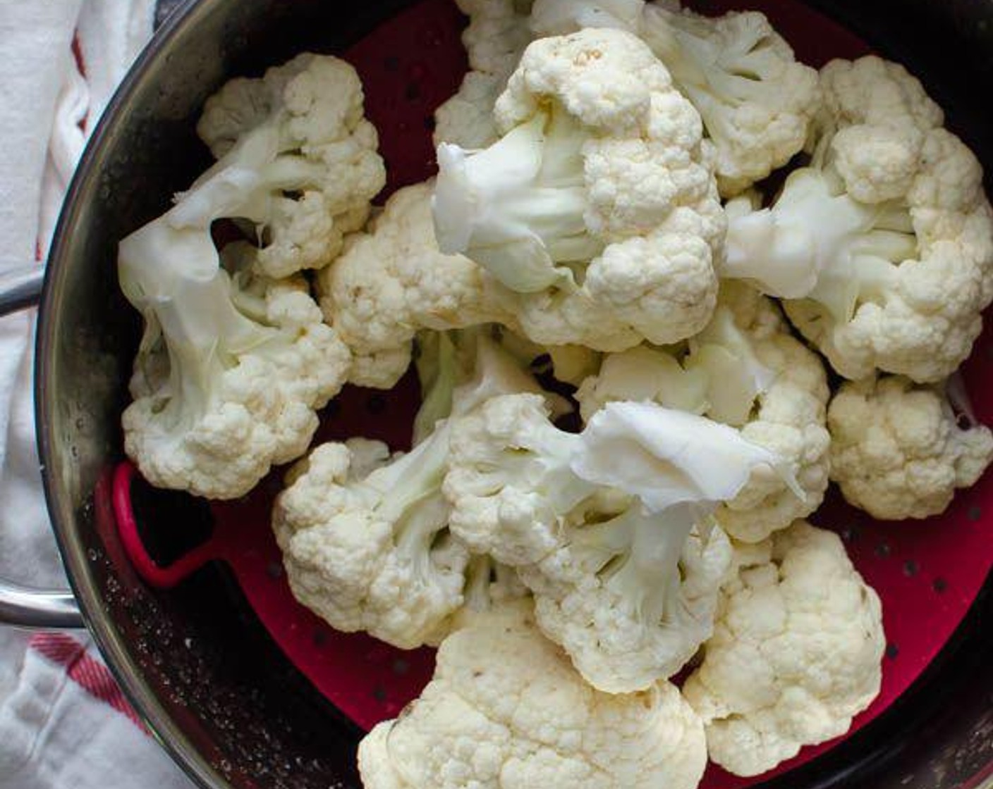 step 3 Meanwhile, set a vegetable steamer into a pot or saucepan with a lid. Add an inch of water to the pot and fill the steamer basket with Cauliflower (1 head).