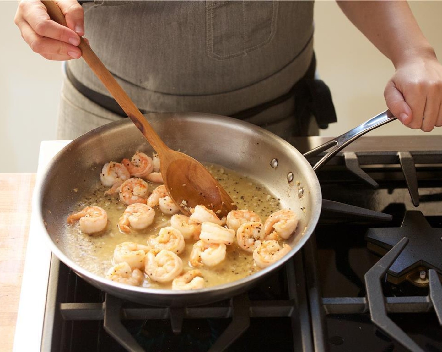 step 6 Add the Freshly Ground Black Pepper (1/2 Tbsp) and a third of a cup of water. Stir. Carefully add the Shrimp (20) in a single layer and cook for two to three minutes.