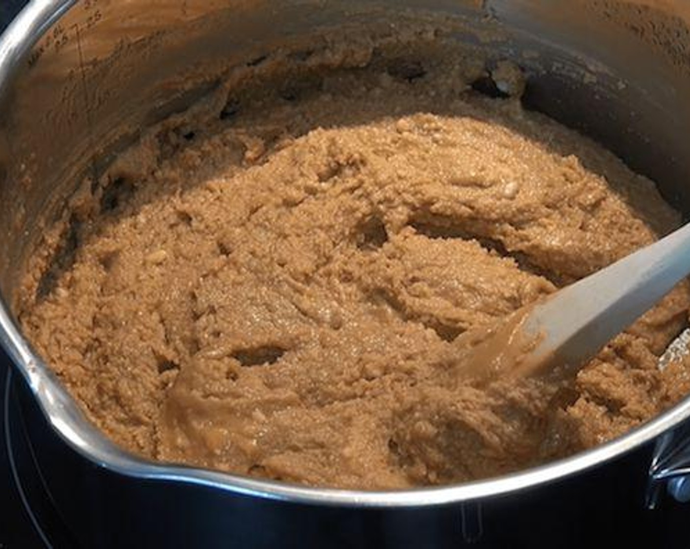 step 3 In a sauce pan over medium heat place the Sliced Butter (3 oz) and let it melt until bubbling. Add in Brown Sugar (1/2 cup), Powdered Confectioners Sugar (1 1/2 cups) and Creamy Natural Peanut Butter (1 cup). Using a wooden spoon mix all the ingredients until melted and smooth. Turn off the heat and add in the Chocolate Chips (1/2 cup) then stir them through.