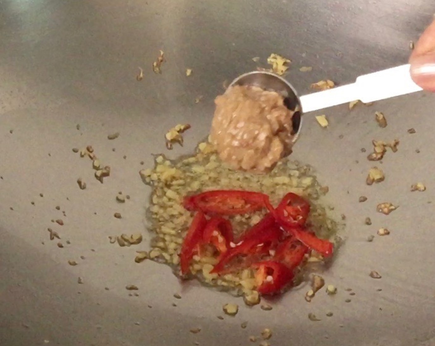 step 8 Then add in the cut red chilies and mixed sauce. Stir fry until fragrant over high heat, about 1 minute.