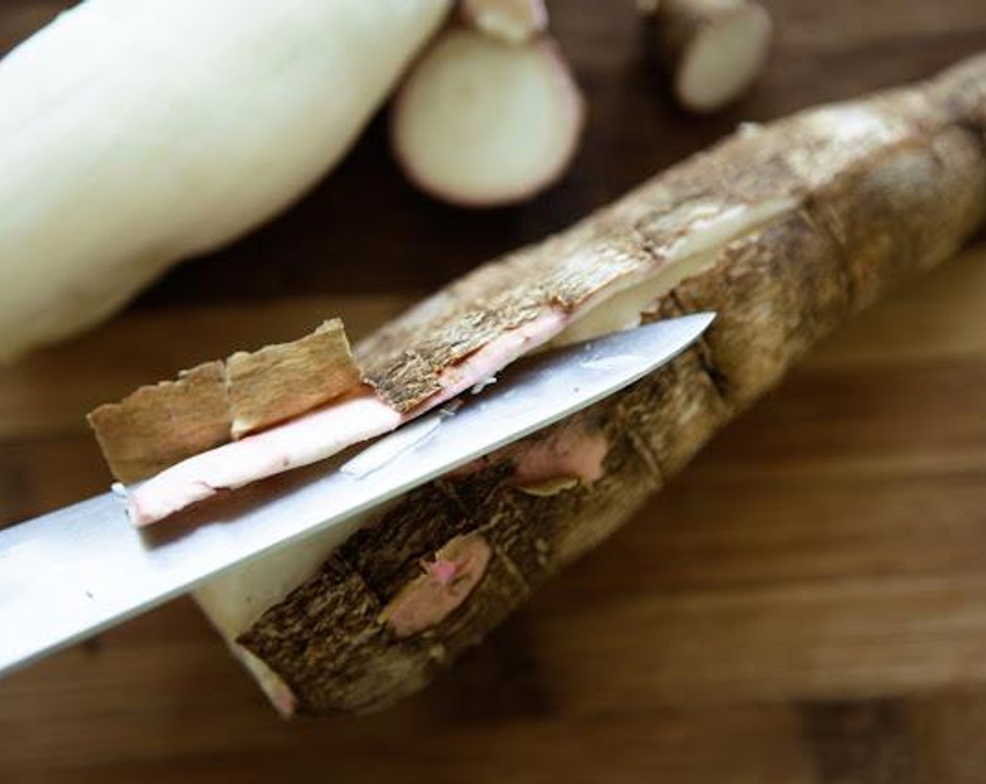 step 2 Trim the ends of the cassava and make a slit lengthways to peel off the outer skin.