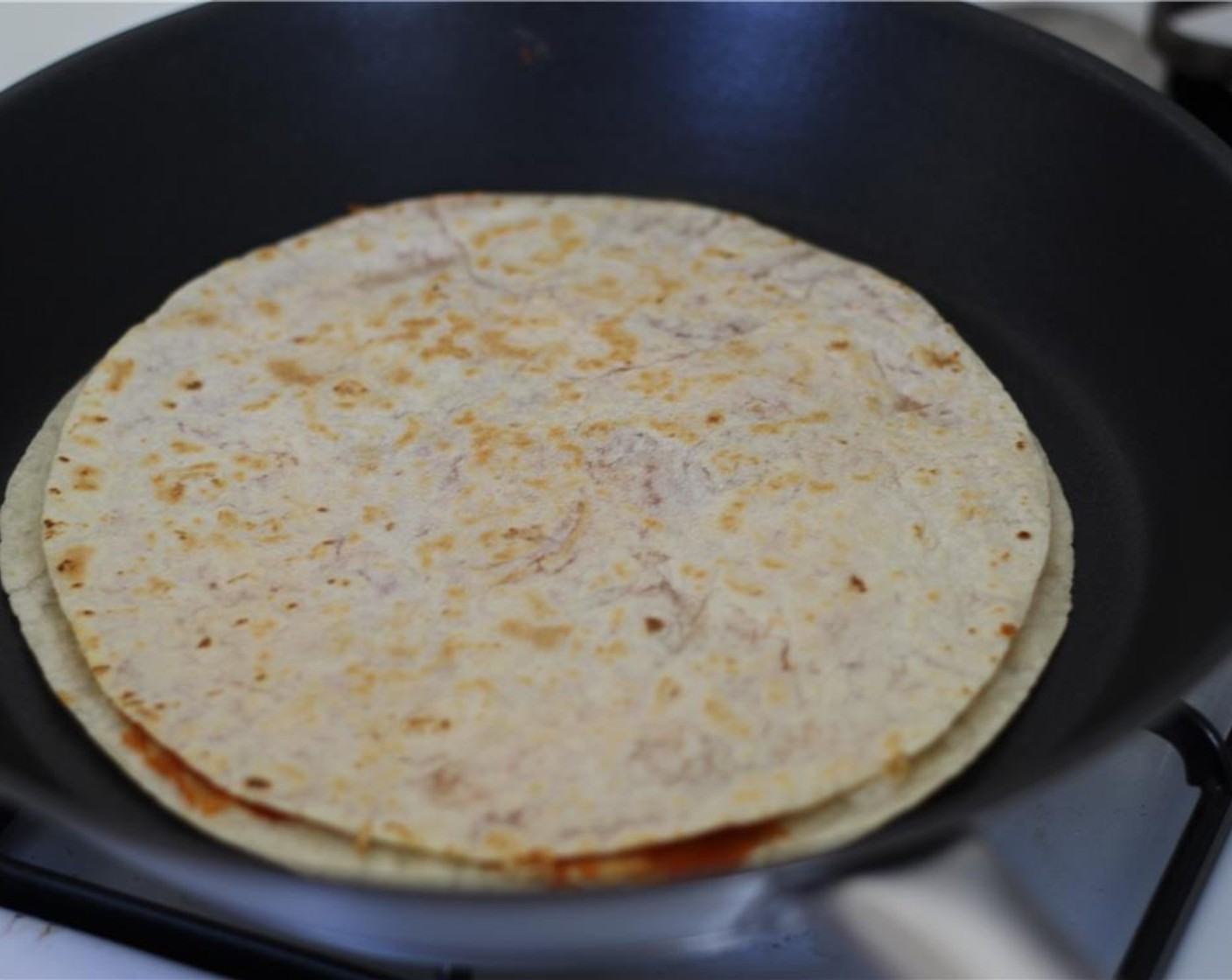 step 3 Now, place the remaining tortilla on top. When the cheese begins to melt, flip the quesadilla to toast the other side for a minute or two.