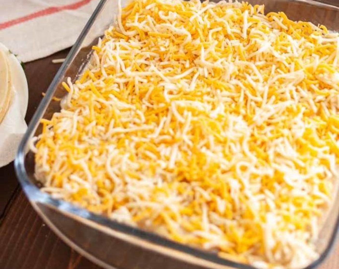 step 7 Spread any remaining enchilada sauce over the top of the enchiladas. Sprinkle with the Shredded Cheese (1 cup).