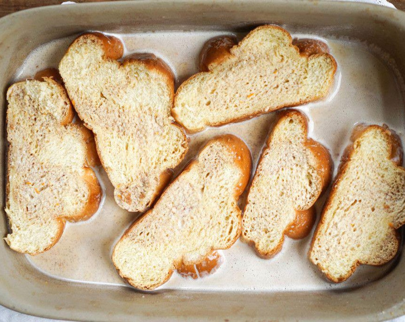 step 4 Pour the custard in a large baking dish, big enough for all bread slices. Lay the Challah Bread (8 slices) in the custard, spooning some of the custard over the top, and allow to soak for 8 minutes.