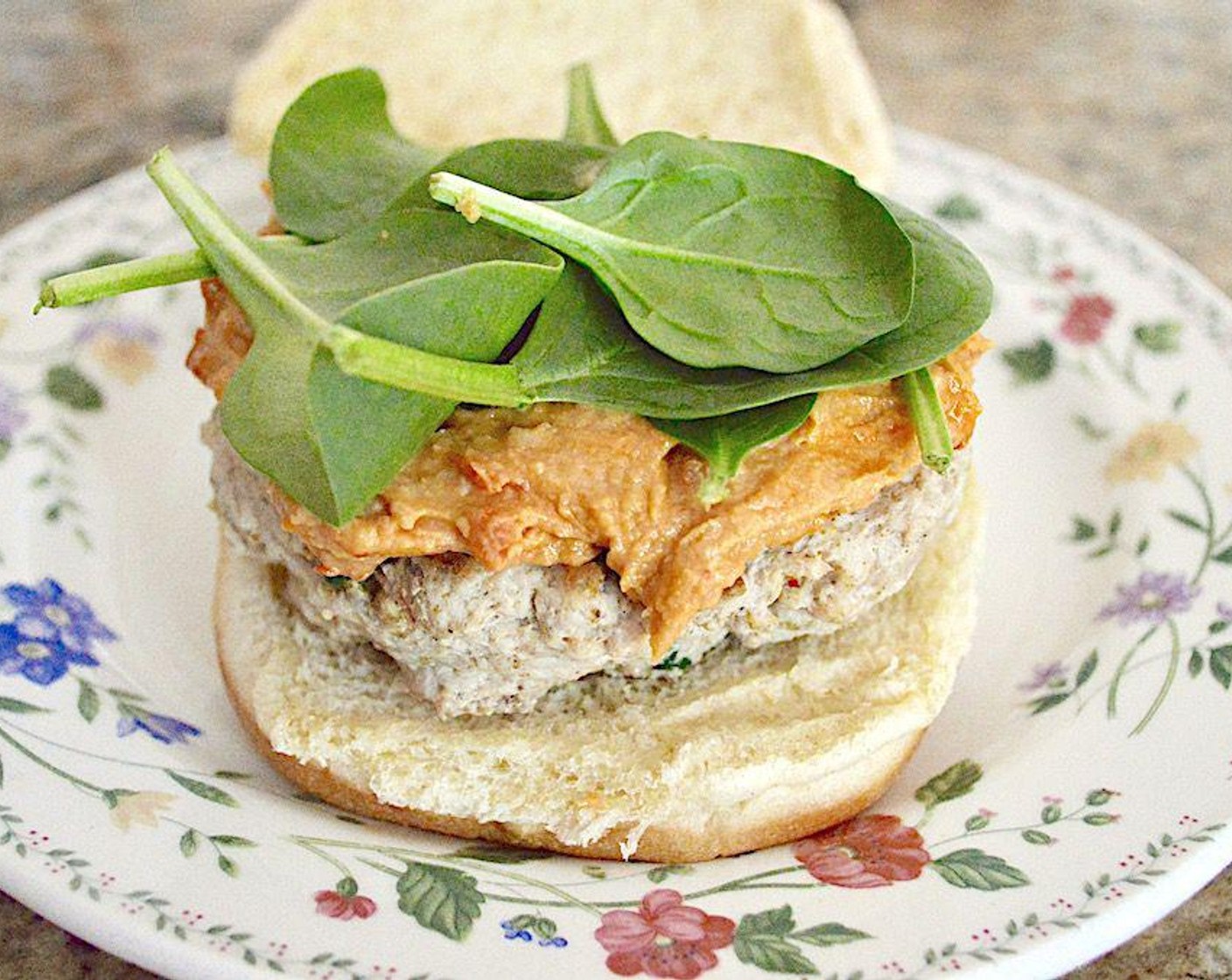 step 3 While they cook, toast the Hamburger Buns (4). Butter with Salted Butter (to taste) once they're done and place a cooked chicken burger on each bottom. Top the patties with a heaping spoonful of the Roasted Red Pepper Hummus (to taste) and a small handful of Fresh Baby Spinach (to taste). Serve them immediately with your favorite side! Serve and enjoy!